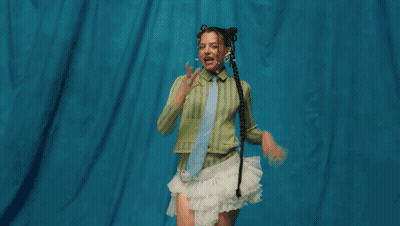 Woman In Green Shirt And White Skirt In Grassy Field GIF