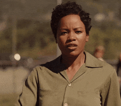 Woman In Green Shirt Making Funny Face And Waving GIF