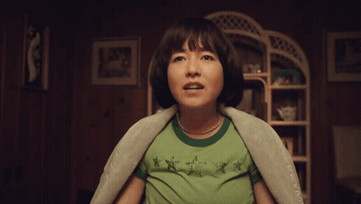 Woman In Green Shirt Screaming In Dark Room GIF
