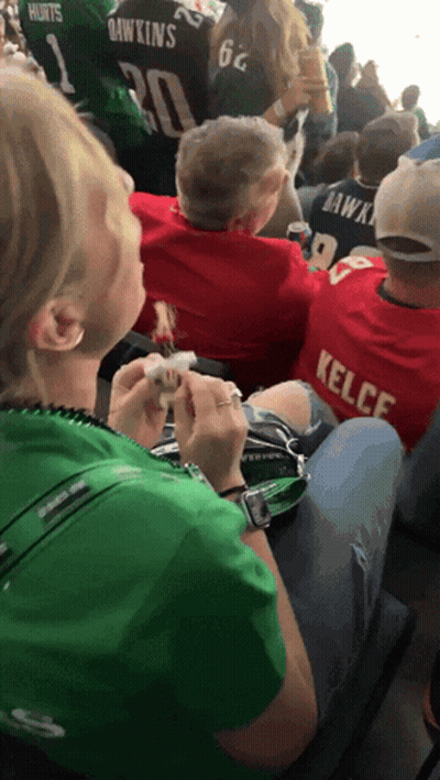 Woman In Green Shirt Sitting Next To Man In Red Kelce Shirt GIF