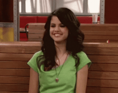 Woman In Green Shirt Smiling On Wooden Bench In Restaurant GIF