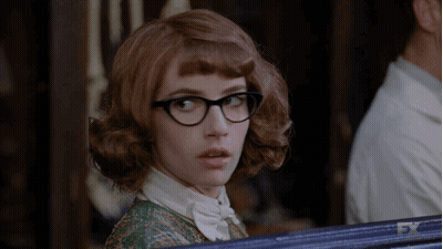 Woman In Green Shirt Standing Before FX Sign GIF