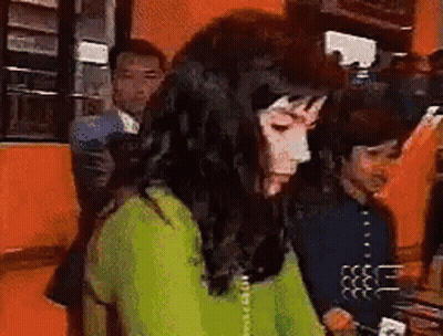 Woman In Green Shirt Talking On Phone While Man Looks On GIF