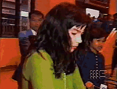 Woman In Green Shirt Talking On Telephone GIF