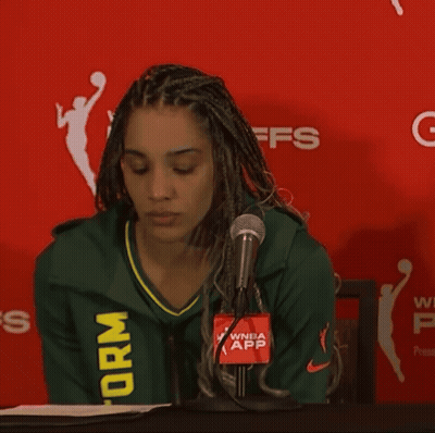 Woman In Green Storm Jersey In Front Of Red Wall GIF