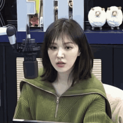 Woman In Green Sweater At Microphone GIF