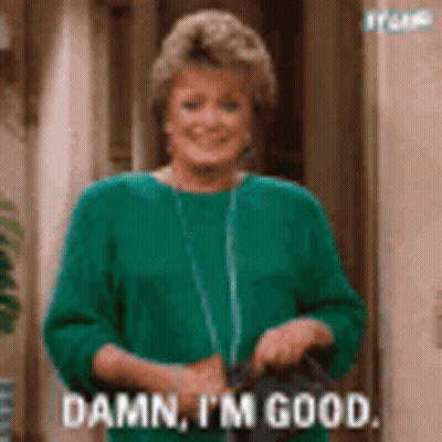 Woman In Green Sweater Holding Black Purse GIF