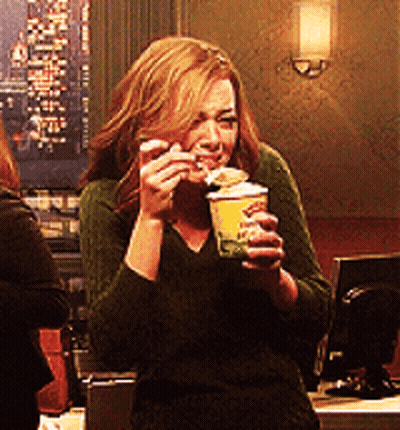Woman In Green Sweater Holding Cup Of Food GIF