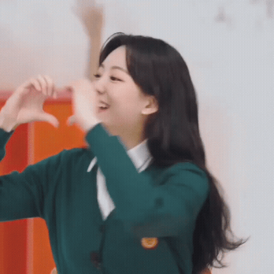 Woman In Green Sweater Making Heart With Hands GIF