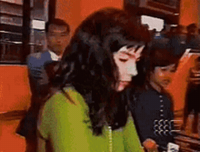 Woman In Green Sweater Sitting With Man In Suit GIF