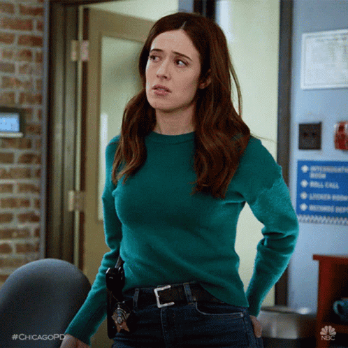 Woman In Green Sweater Standing In Front Of Door GIF