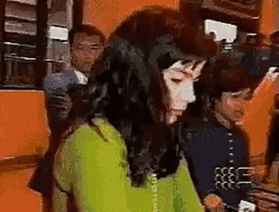 Woman In Green Sweater Talking On Phone While Man Looks On GIF