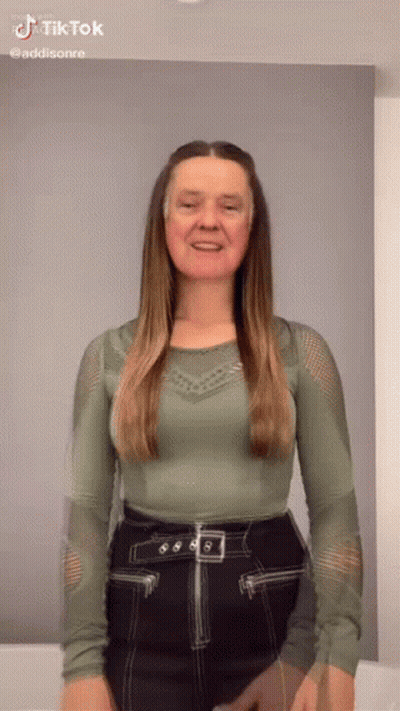 Woman In Green Top And Black Skirt Smiling GIF