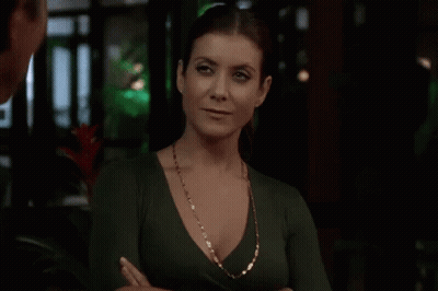 Woman In Green Top And Gold Necklace With Arms Crossed GIF