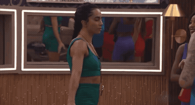 Woman In Green Top Standing Before Mirror GIF