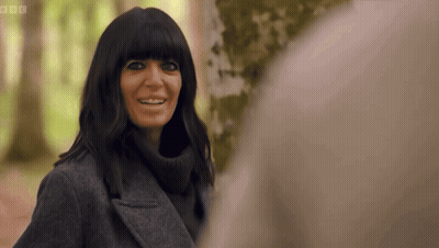 Woman In Grey Coat Smiling In Front Of Tree GIF