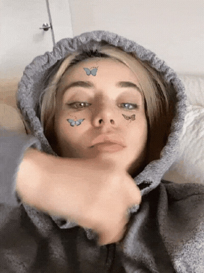 Woman In Grey Hoodie With Butterflies On Face GIF