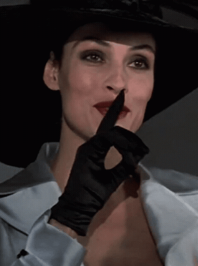 Woman In Hat And Black Glove Shushing GIF