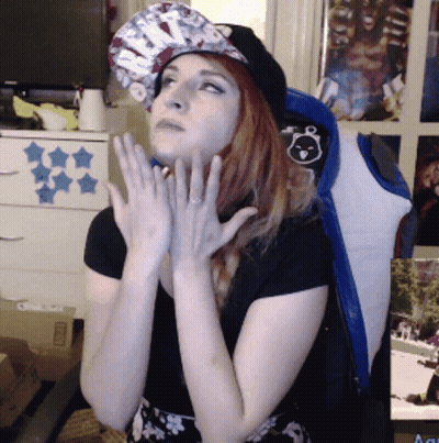 Woman In Hat And Black Shirt Hands On Chin GIF