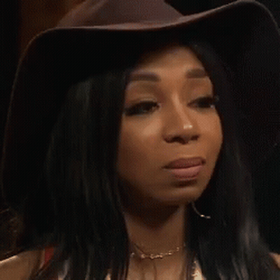 Woman In Hat And Earrings Looking At Camera GIF