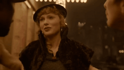 Woman In Hat And Fur Coat Talking To Man GIF