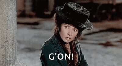 Woman In Hat And Jacket By Wall Saying G'on GIF