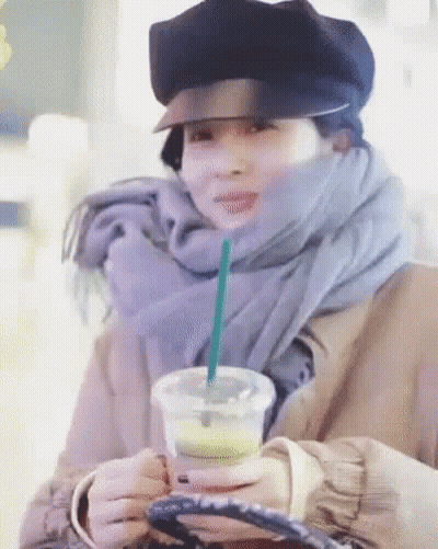 Woman In Hat And Scarf Holding Coffee With Straw GIF