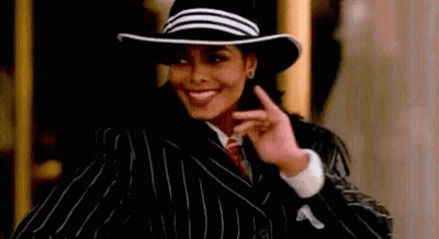 Woman In Hat And Striped Suit Smiling And Pointing GIF