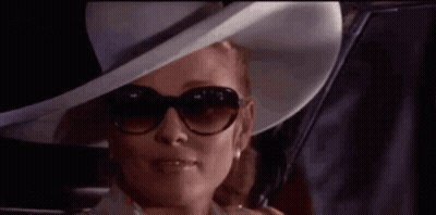 Woman In Hat And Sunglasses Looking Out Car Window GIF