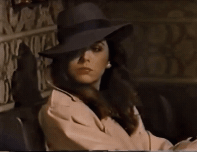 Woman In Hat And Trench Coat Sitting GIF