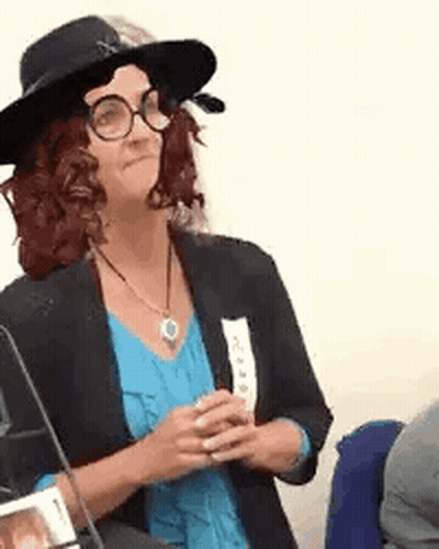 Woman In Hat Glasses And Blue Shirt Sitting GIF