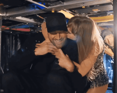 Woman In Hat Kissing Man On Cheek GIF