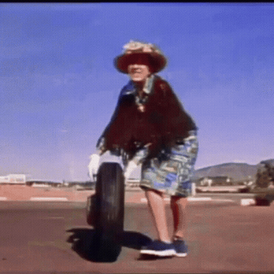 Woman In Hat Standing Next To Tire GIF