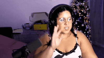 Woman In Headphones And Glasses At Microphone By Christmas Tree GIF