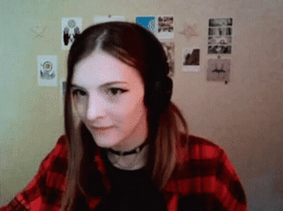 Woman In Headphones And Plaid Shirt Sitting By Wall GIF