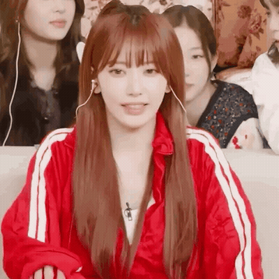 Woman In Headphones And Red Jacket On Couch GIF
