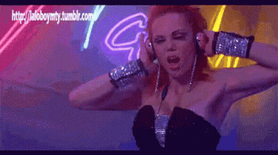 Woman In Headphones Dancing In Front Of Neon Sign Saying G GIF