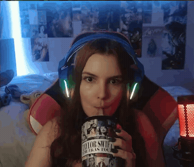Woman In Headphones Drinking From Taylor Swift Cup GIF