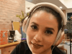 Woman In Headphones Rolls Her Eyes GIF