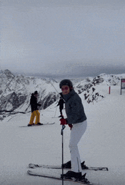 Woman In Helmet And Goggles Holding Ski Pole In Snow GIF