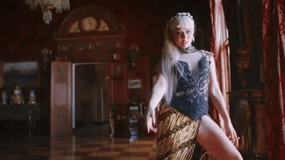 Woman In High Slit Dress Covering Nose GIF