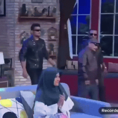 Woman In Hijab Sitting On Couch In Front Of Man In Leather Jacket GIF