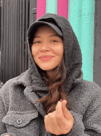Woman In Hooded Jacket And Hat Making Heart GIF