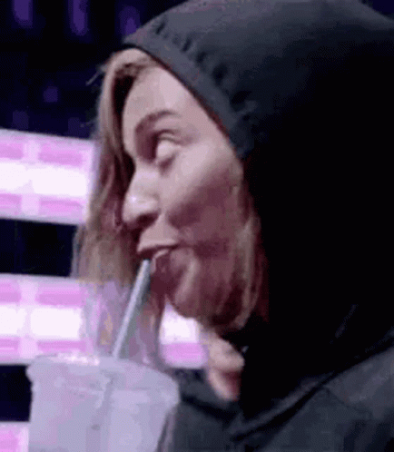 Woman In Hooded Jacket Drinking Through Straw GIF