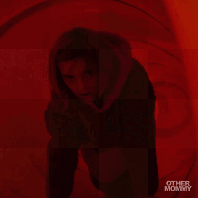 Woman In Hooded Jacket In Red Room With Other Mommy GIF