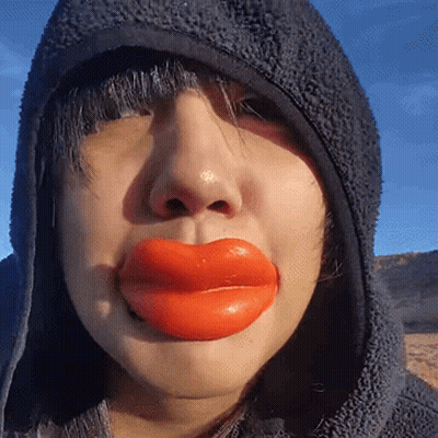Woman In Hooded Jacket With Huge Red Lips GIF