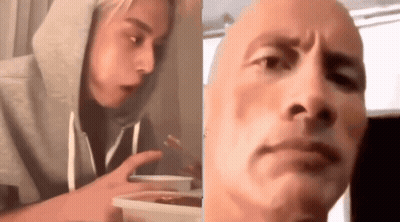 Woman In Hoodie Eating Food Next To Bald Man GIF