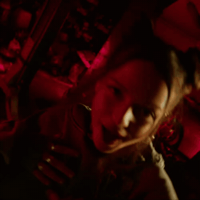 Woman In Hoodie With Skulls In Dark Room GIF