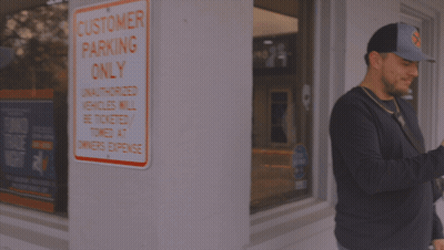 Woman In Hooters Outfit In Front Of Mural GIF