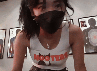 Woman In Hooters Shirt And Black Mask GIF